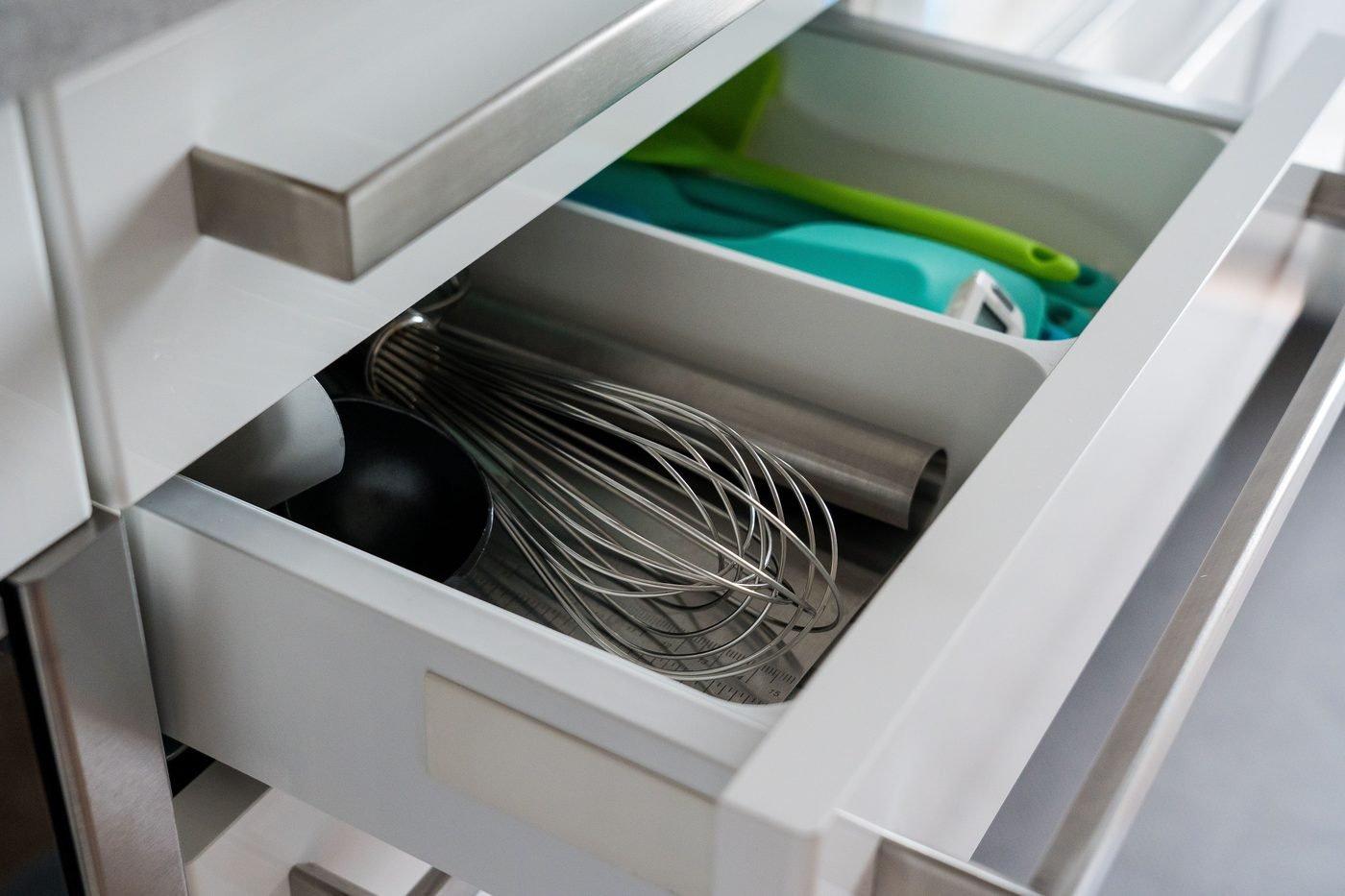 Cajón de cocina abierto con utensilios separados por compartimentos.